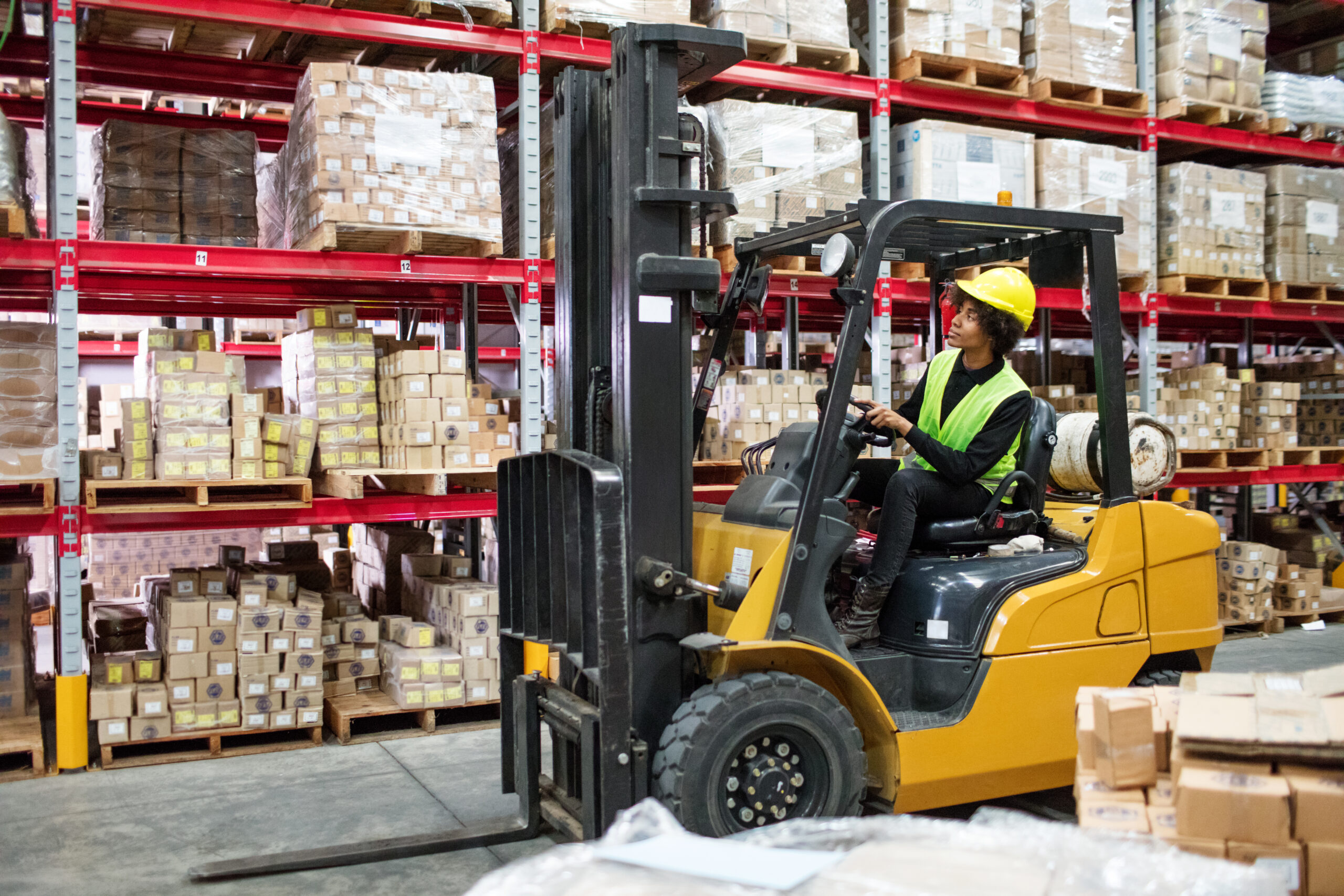 Woman safely operating forklift in warehouse